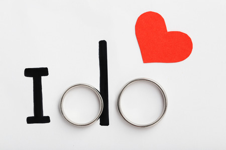 Silver wedding rings with red heart and words I doの写真素材