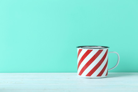 Striped cup on blue wooden tableの写真素材