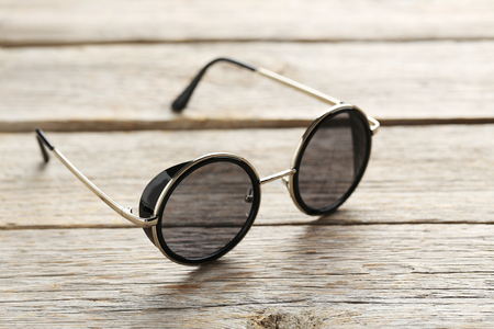 Black sunglasses on a grey wooden tableの写真素材