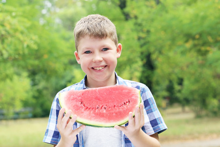 Portrait of  little boy with slice of watermelon in the parkの写真素材