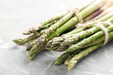 Fresh green asparagus on a grey tableの写真素材