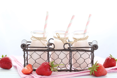 Strawberry yogurt in bottle on wooden tableの写真素材