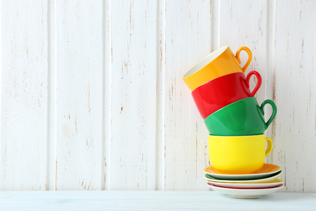 Colorful cups on a blue wooden tableの写真素材
