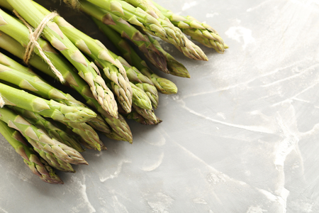 Fresh green asparagus on a grey tableの写真素材