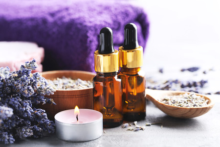 Lavender oil with soap and flowers on grey tableの写真素材
