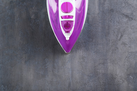 Electric iron on a grey tableの写真素材