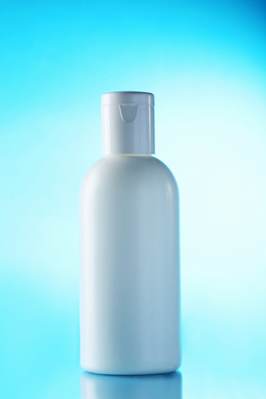 White cosmetic bottle on a blue backgroundの写真素材