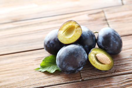 Tasty and ripe plums on brown wooden tableの写真素材