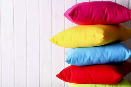 Colorful pillows on a white wall paneling backgroundの写真素材