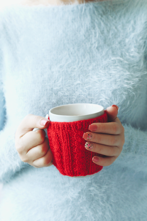 Woman hands holding cup of coffee on wooden tableの写真素材