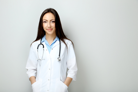 Portrait of young medical doctor on a grey backgroundの写真素材