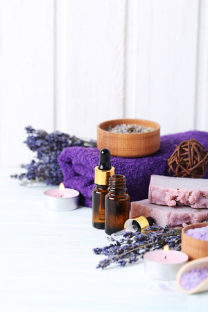 Lavender oil with soap and flowers on white wooden tableの写真素材