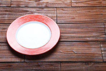 Empty plate on brown wooden tableの写真素材