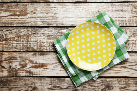 Empty plate with napkin on brown wooden tableの写真素材