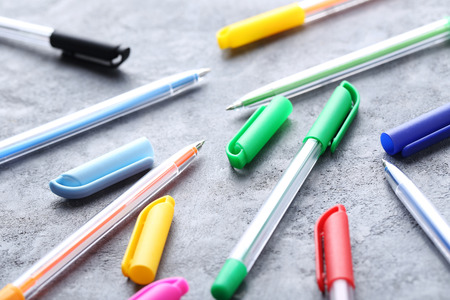 Colored pens on a grey wooden tableの写真素材