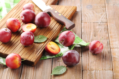Fresh plums on a brown wooden tableの写真素材