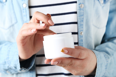 Young woman hands holding bowl with creamの写真素材