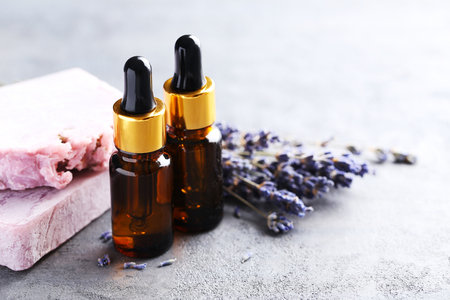Lavender oil and flowers on grey tableの写真素材