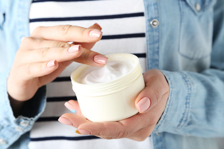 Young woman hands holding bowl with creamの写真素材