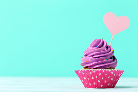 Tasty cupcake on a green background