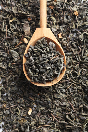 Heap of dry tea in wooden spoonの写真素材