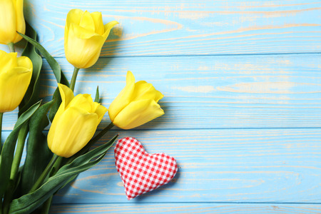 Bouquet of yellow tulips on a blue wooden tableの写真素材