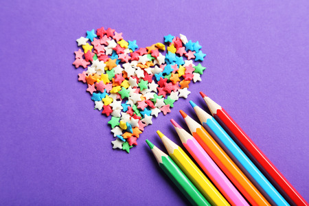Colorful sprinkles with pencils on the purple backgroundの写真素材