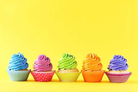 Tasty cupcakes on a yellow backgroundの写真素材