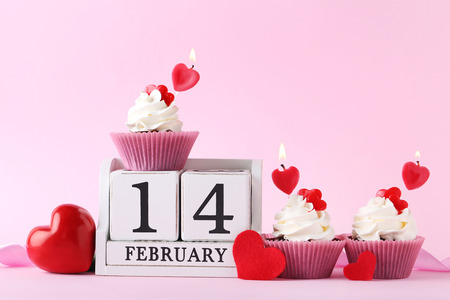 Tasty cupcakes with cube calendar on pink backgroundの写真素材