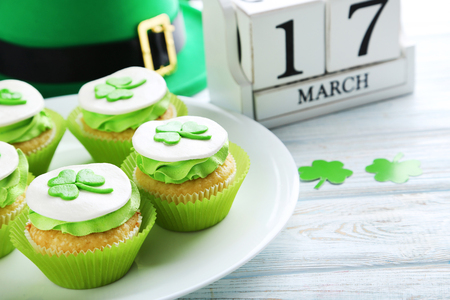 Delicious cupcakes with clover leaf on white wooden tableの写真素材