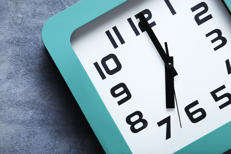 Green clock on a grey wooden tableの写真素材