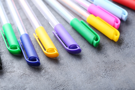Colored pens on a grey wooden table