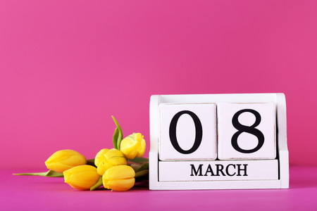 Bouquet of tulips with cube calendar on pink background