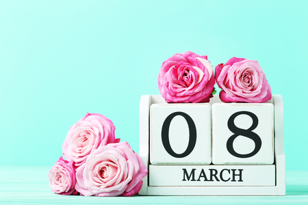 Beautiful pink roses with cube calendar on green backgroundの写真素材