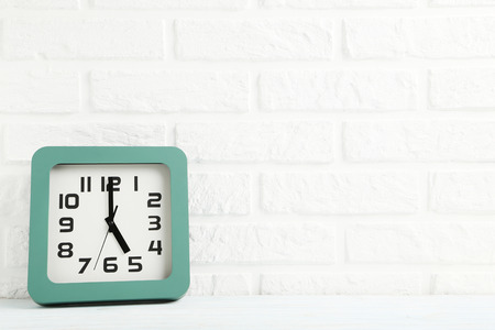 Green clock on a brick wall backgroundの写真素材