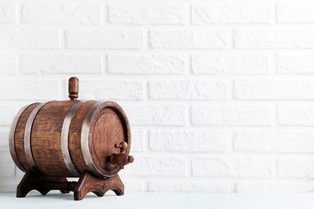 Wooden barrel with iron rings on brick wall backgroundの写真素材