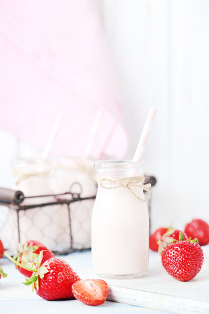 Strawberry yogurt in bottle on wooden tableの写真素材