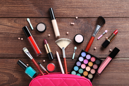 Different makeup cosmetics on brown wooden tableの写真素材
