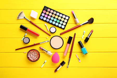 Different makeup cosmetics on yellow wooden tableの写真素材