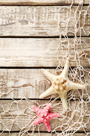 Fishing net with starfish on wooden tableの写真素材