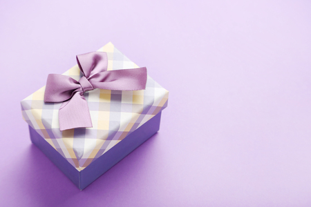 Gift box with ribbon on purple backgroundの写真素材