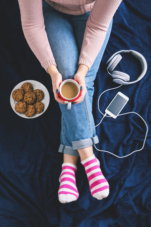 Woman with cup of coffee sitting on blue plaidの写真素材