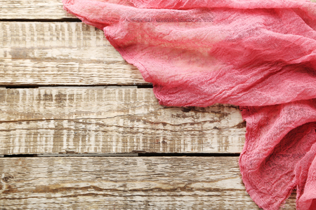 Red gauze fabric on brown wooden tableの写真素材