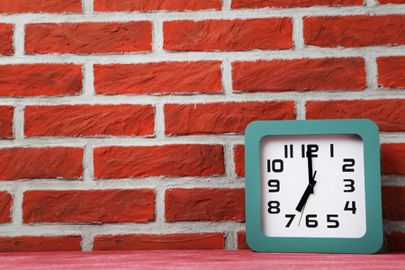 Green clock on a brick wall backgroundの写真素材