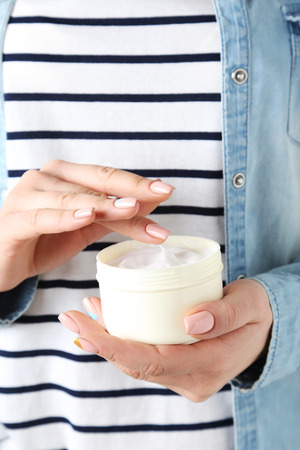 Young woman hands holding bowl with creamの写真素材