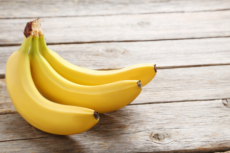 Sweet bananas on grey wooden tableの写真素材