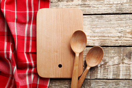 Red napkin, cutting board and spoon on a grey wooden tableの写真素材