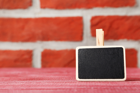 Small blackboard on a brick wall backgroundの写真素材