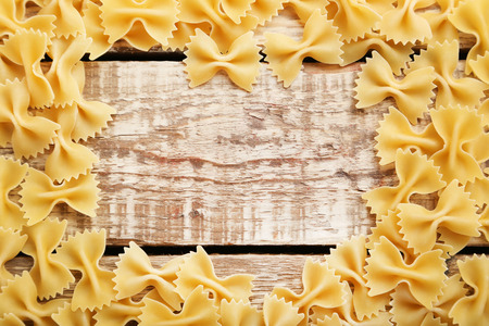 Bow tie pasta on brown wooden tableの写真素材