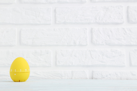 Yellow egg timer on a brick wall backgroundの写真素材